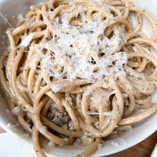 a bowl of spaghetti with mushrooms and parmesan cheese