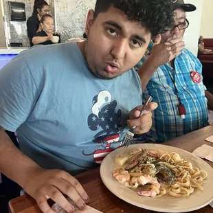 a man eating a plate of pasta