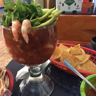 a bowl of soup with shrimp, tortillas, and tortillas