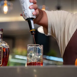 a bartender pouring a drink at a bar