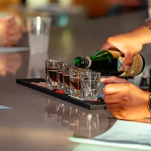 a person pouring a drink at a bar