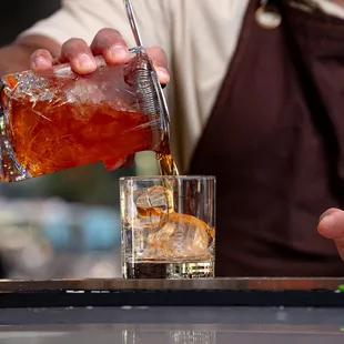a bartender pouring a drink at a bar