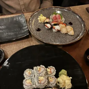 a sushi dish on a black plate