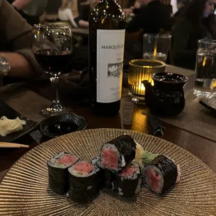 a plate of sushi and a bottle of wine