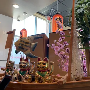 a wooden boat with a cat figurine on it
