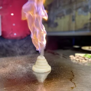 a small cone of food being sprinkled with smoke