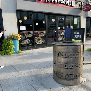 a trash can outside a restaurant