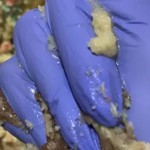 a gloved hand holding a piece of bread