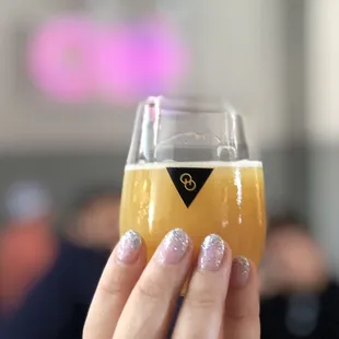 a hand holding a glass of beer