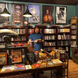 The main room of the bookstore, complete with sci-fi and fantasy artwork above a wall of bookshelves.