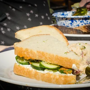 a sandwich on a plate with pickles