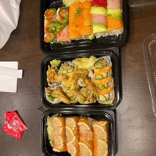 three trays of sushi on a table