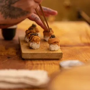 a person chopping sushi on a cutting board