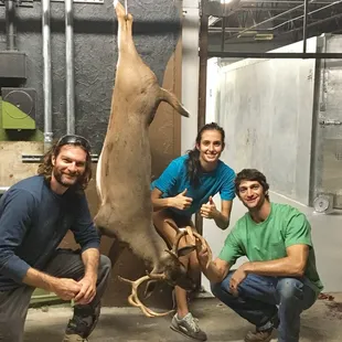 a group of people posing with a deer