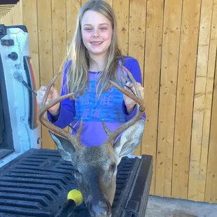 a young girl holding a deer