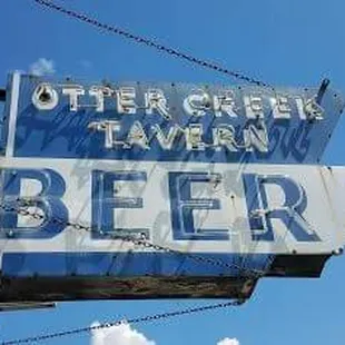the neon sign for otter creek tavern