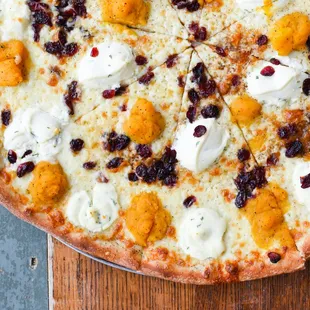 a pizza topped with cheese and cranberries