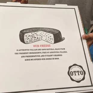 a pizza box with a piece of cheese on it