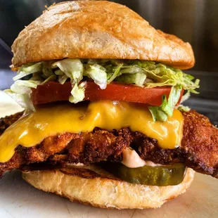 a chicken sandwich with lettuce, tomato, and cheese