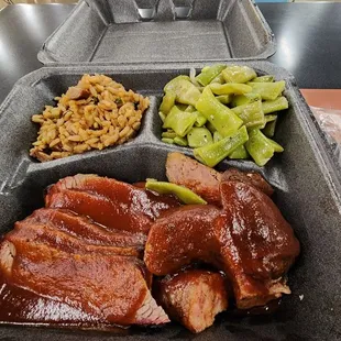 Two meat plate with green beans and dirty rice.