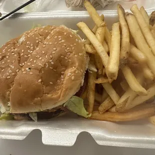 a hamburger and fries in a styrofoam container