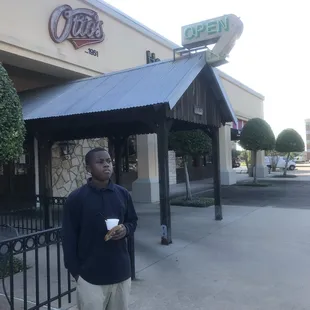 a man standing in front of a coffee shop