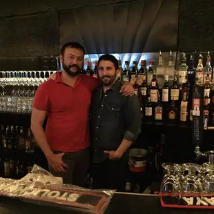 two men standing in front of a bar