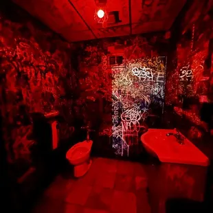 a bathroom with graffiti on the walls