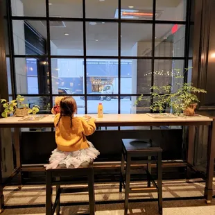 a little girl sitting at a table