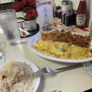 Biscuits and gravy and Swiss Cheese and Bacon Omelette with hash browns and water.