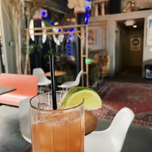 a hand holding a tall glass of iced tea