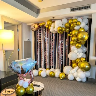 Rose gold, gold, and white bachelorette backdrop setup in the Cosmopolitan suite.