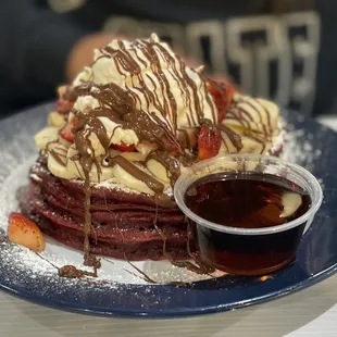 Red velvet pancakes with bananas, Nutella, strawberries and whipped cream.