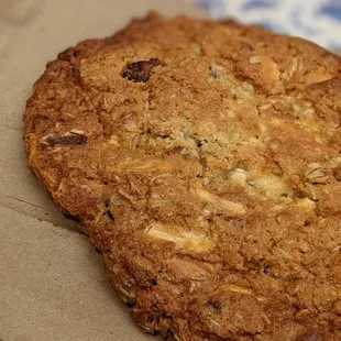 a cookie on a table with a glass of orange juice