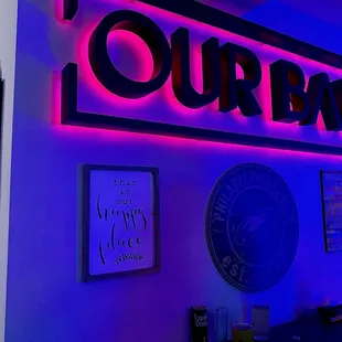 a man standing in front of a neon sign