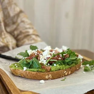 a person sitting at a table with a sandwich