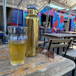 a beer and sunglasses on a picnic table