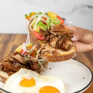 Popo: Sourdough toast, avocado, carnitas, cherry tomato pico de gallo served with 2 eggs.