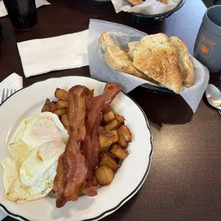Eggs over easy, bacon, fried hash browns, and rye toast.