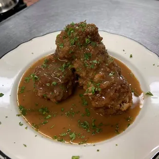 a plate of meatballs with gravy
