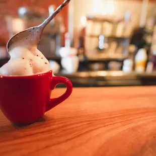 a red cup of hot chocolate with a spoon sticking out of it