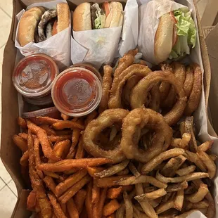 Two cheeseburgers, one triple cheeseburger, onion rings, sweet potato fries, and regular fries