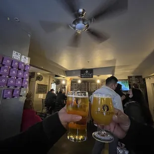 two people holding glasses of beer