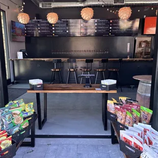 a table and chairs in front of a bar