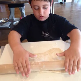 Rolling out pizza dough at Family Night:Pizza Party class July '17
