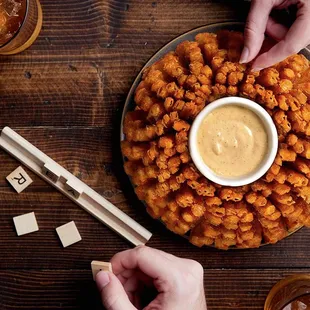a plate of fried tater tots with dipping sauce