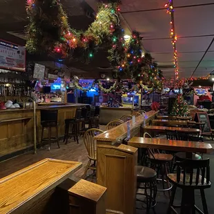 a bar with christmas lights hanging from the ceiling