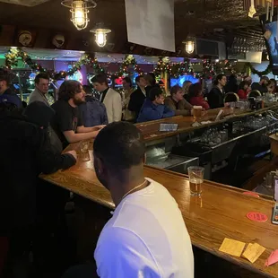 a large group of people sitting at a bar