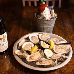 a plate of oysters and a bottle of wine