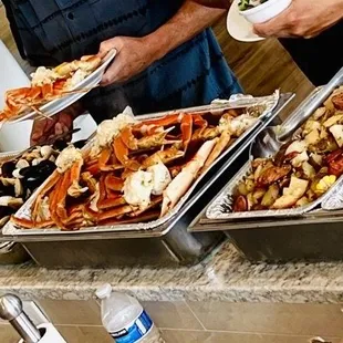 Clambake buffet (lobster not shown). Biscuits, shrimp, clams, crab legs, sausage &amp; potatoes, corn.